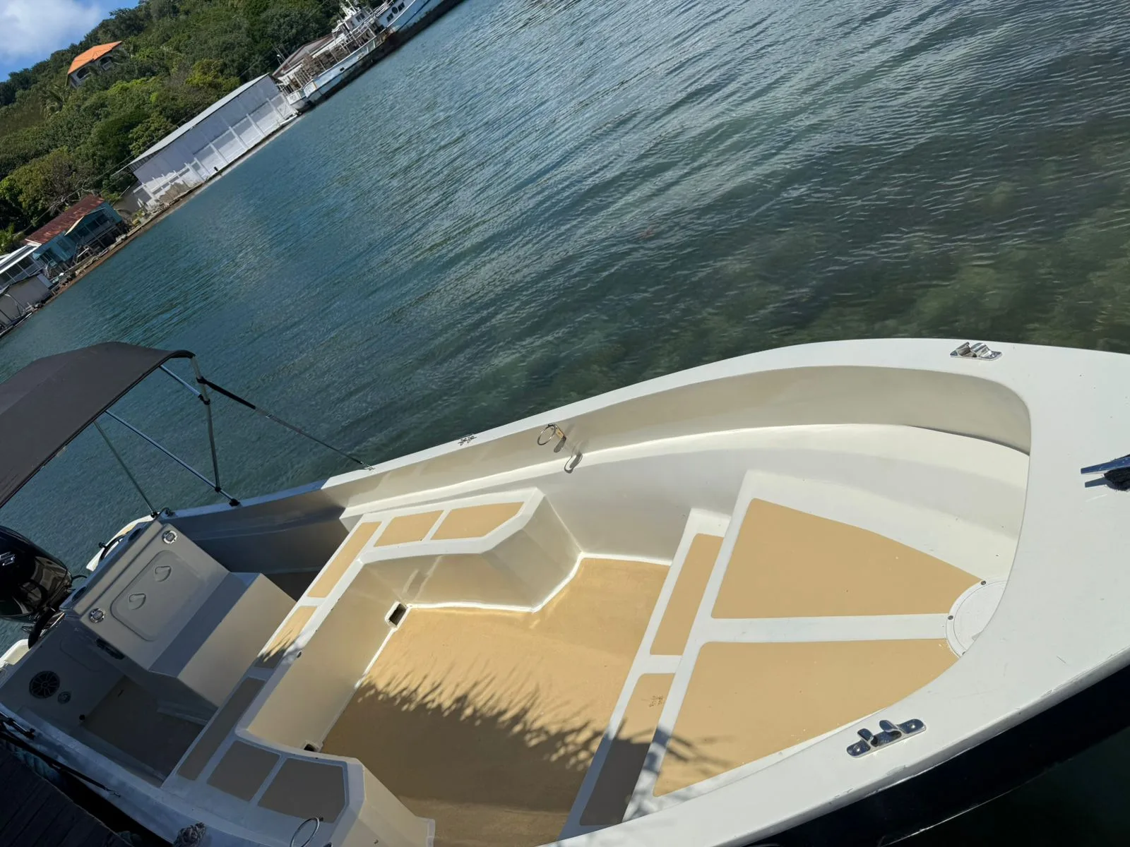 Bote charter privado visto desde arriba en agua turquesa clara, Roatán